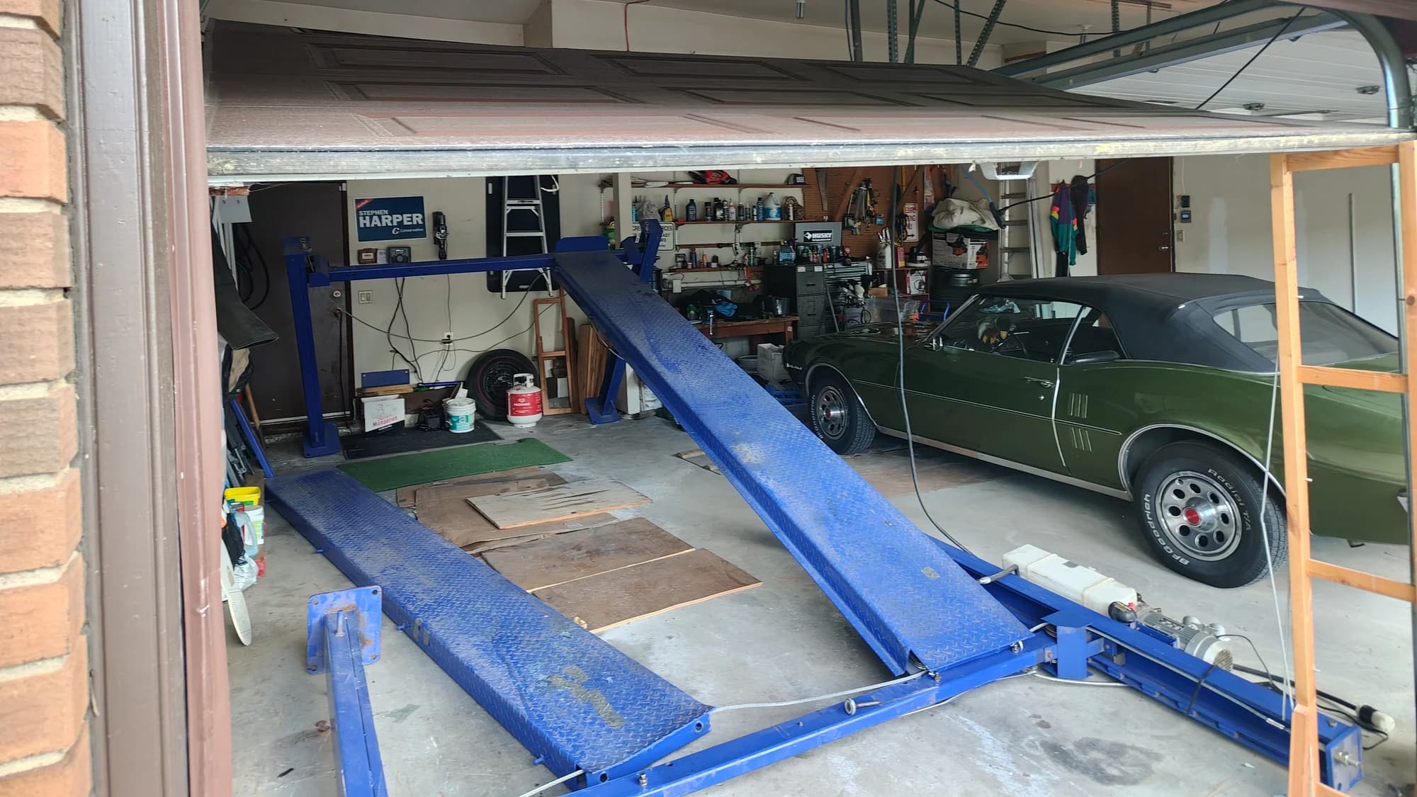 Collapsed car lift and off-track garage door inside a Canterbury Drive SW Calgary garage