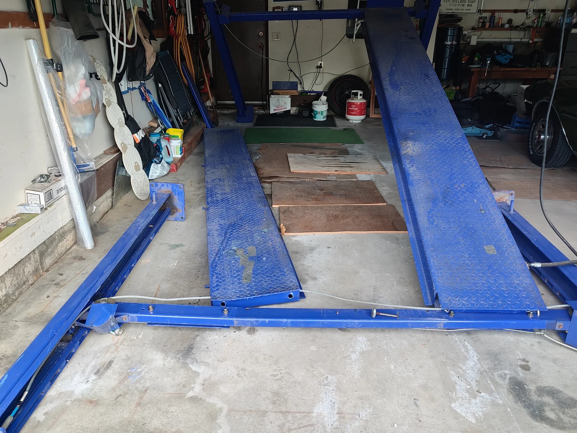 Failed car lift setup inside a Canterbury Drive SW Calgary garage after it struck the garage door