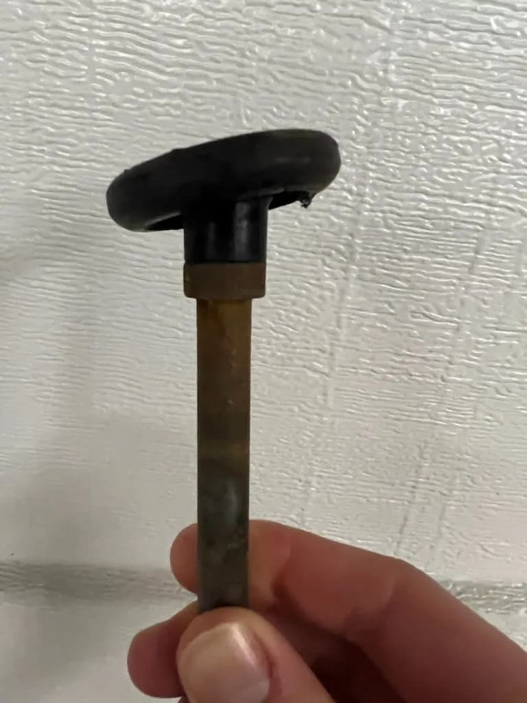 Bent plastic garage door roller removed during a Garage Door Fix inspection