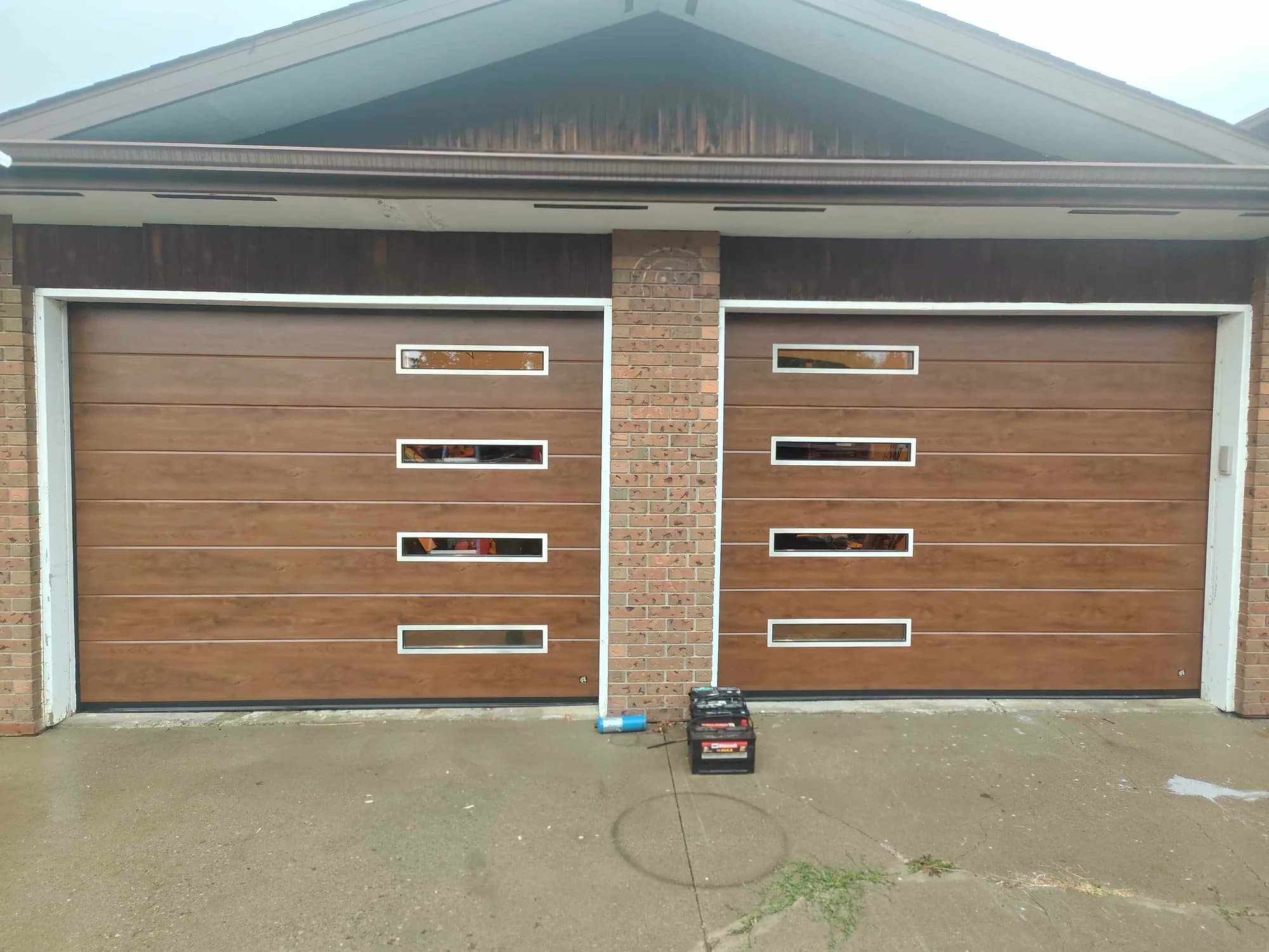 Two Old Oak Ryterna Midrib garage doors with slim stainless steel windows in Pincher Creek Alberta