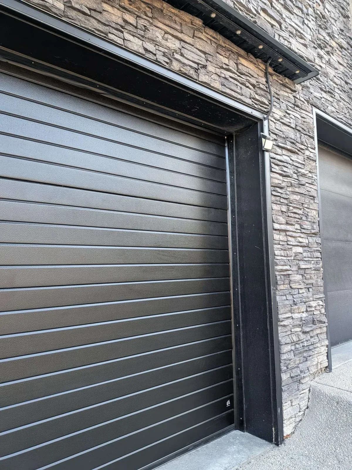 Angled view of the RAL 9004 Signal Black Ribbed panels on a Ryterna walk-through garage door