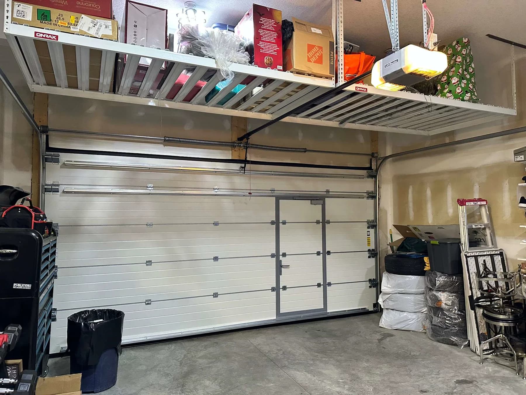 Interior hardware and track view of a 16 by 8 Ryterna walk-through garage door