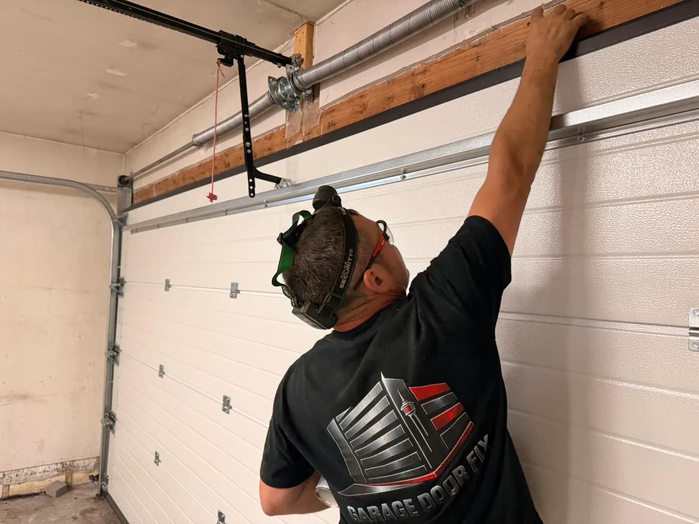 Garage Door Fix technician adjusting the upper seal on a Ryterna garage door installation in Deer Run