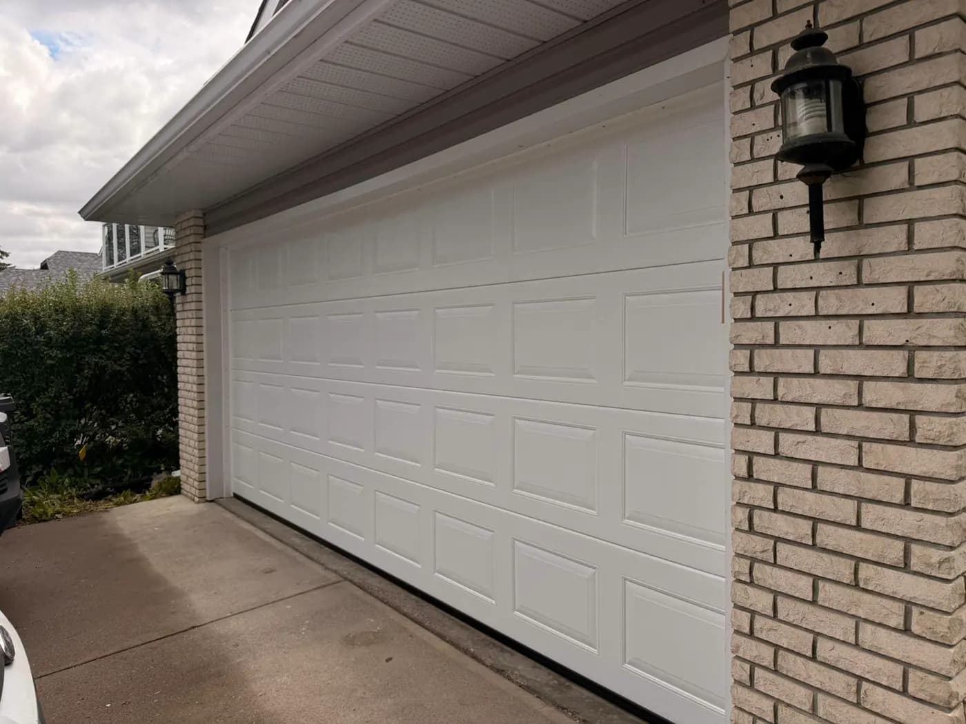 Angled exterior view of a white Ryterna Cassette garage door in Deer Run Calgary