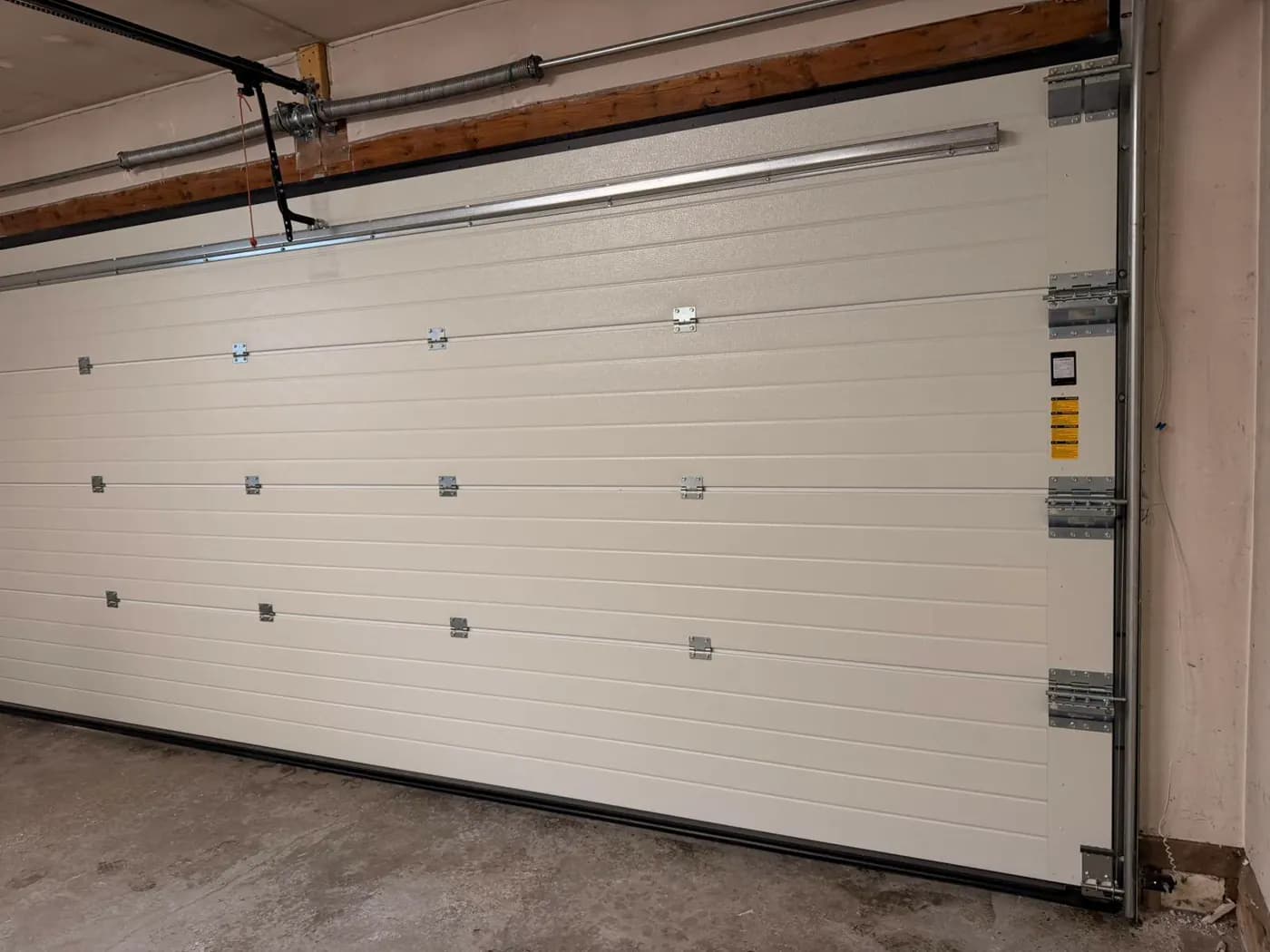 Interior view of a Ryterna sectional door showing hinges tracks struts and bottom seal