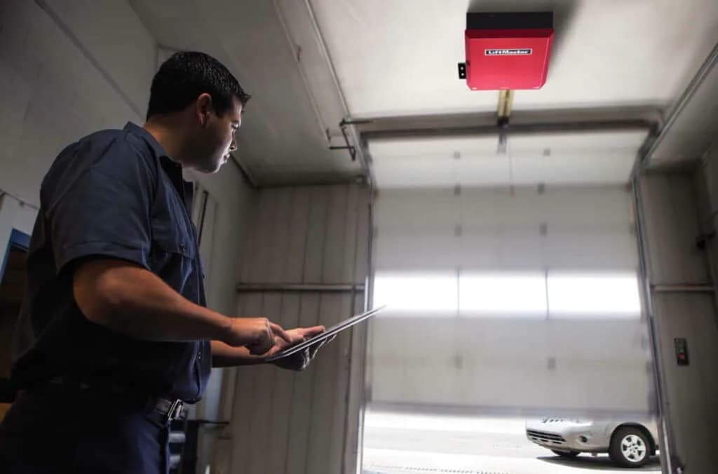 Garage door hardware being checked during a maintenance visit