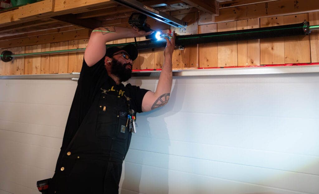 Garage Door Fix technician measuring a torsion spring system